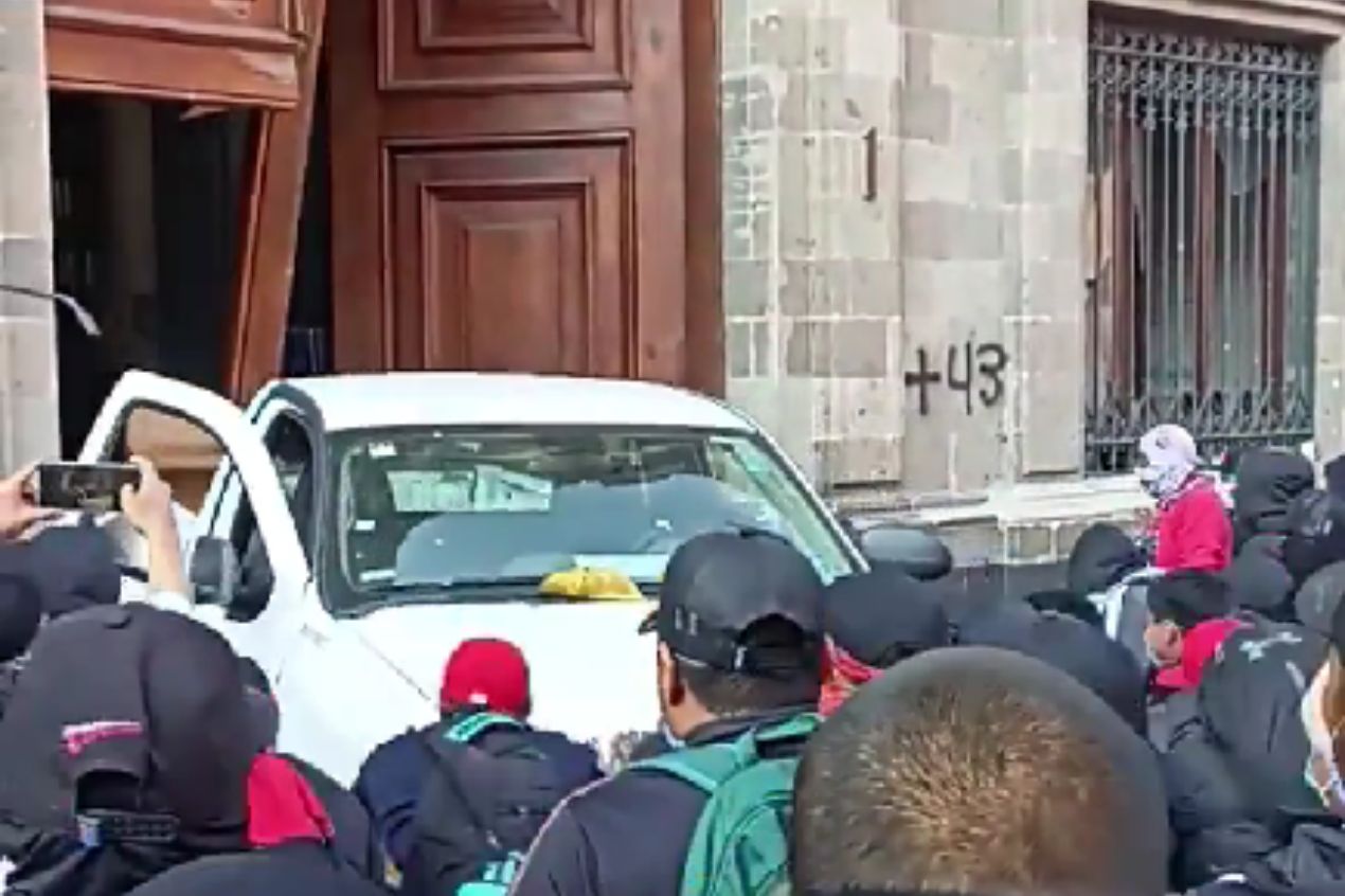 Presuntos normalistas de Ayotzinapa tiran puerta de Palacio Nacional